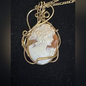 Hand-carved shell cameo pendant set in a decorative,free-form gold frame
